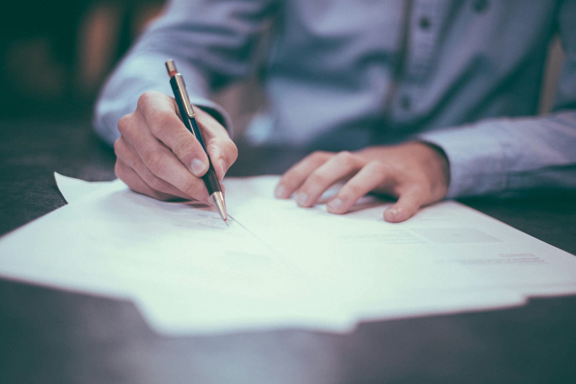 Person writing on form 